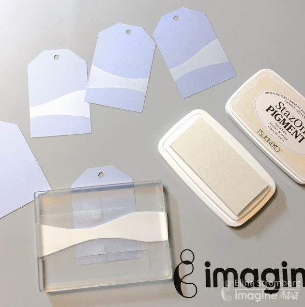 Stamp a snowy hill shape on each tag using white StazOn Pigment ink.