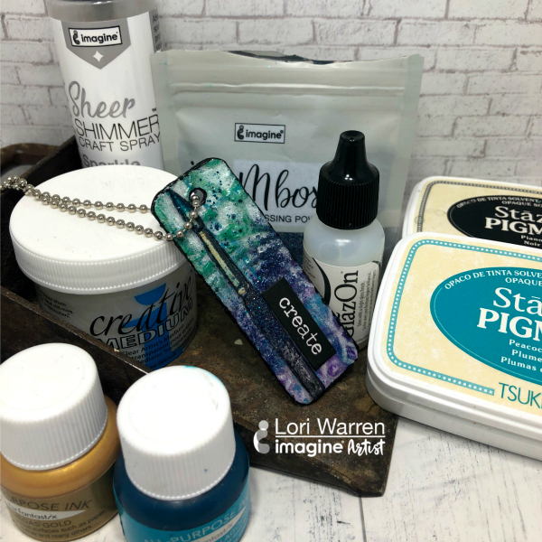 A Gift for Someone Special – Create a Chipboard Pendant with StazOn. A beautiful teal and blue jewelry piece that features a paintbrush image and reads "create".